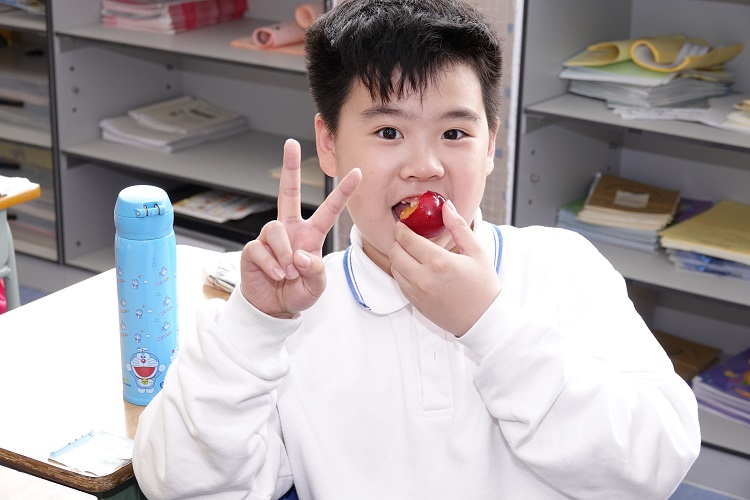 学生愉快地享受吃水果的乐趣。