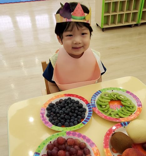小朋友品尝各式各样的水果，吃得津津有味。